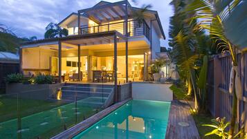 Relax in a spacious living area with a large open-plan design, featuring a covered outdoor seating area and pool.