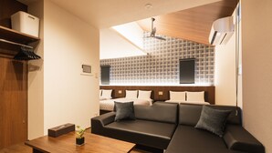 Een moderne woonkamer met een bank, een houten salontafel en een plafondventilator.