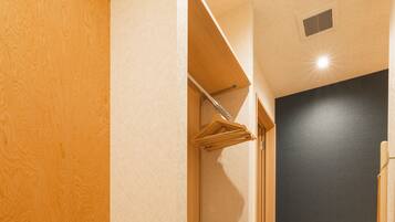 Un baño con banco de madera, suelo de baldosas y pared oscura.