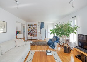 Relax in this stylish living room with a sofa, coffee table, bookshelf, and potted plant.