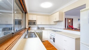 Una cocina moderna con armarios blancos, electrodomésticos de acero inoxidable y encimera de madera.