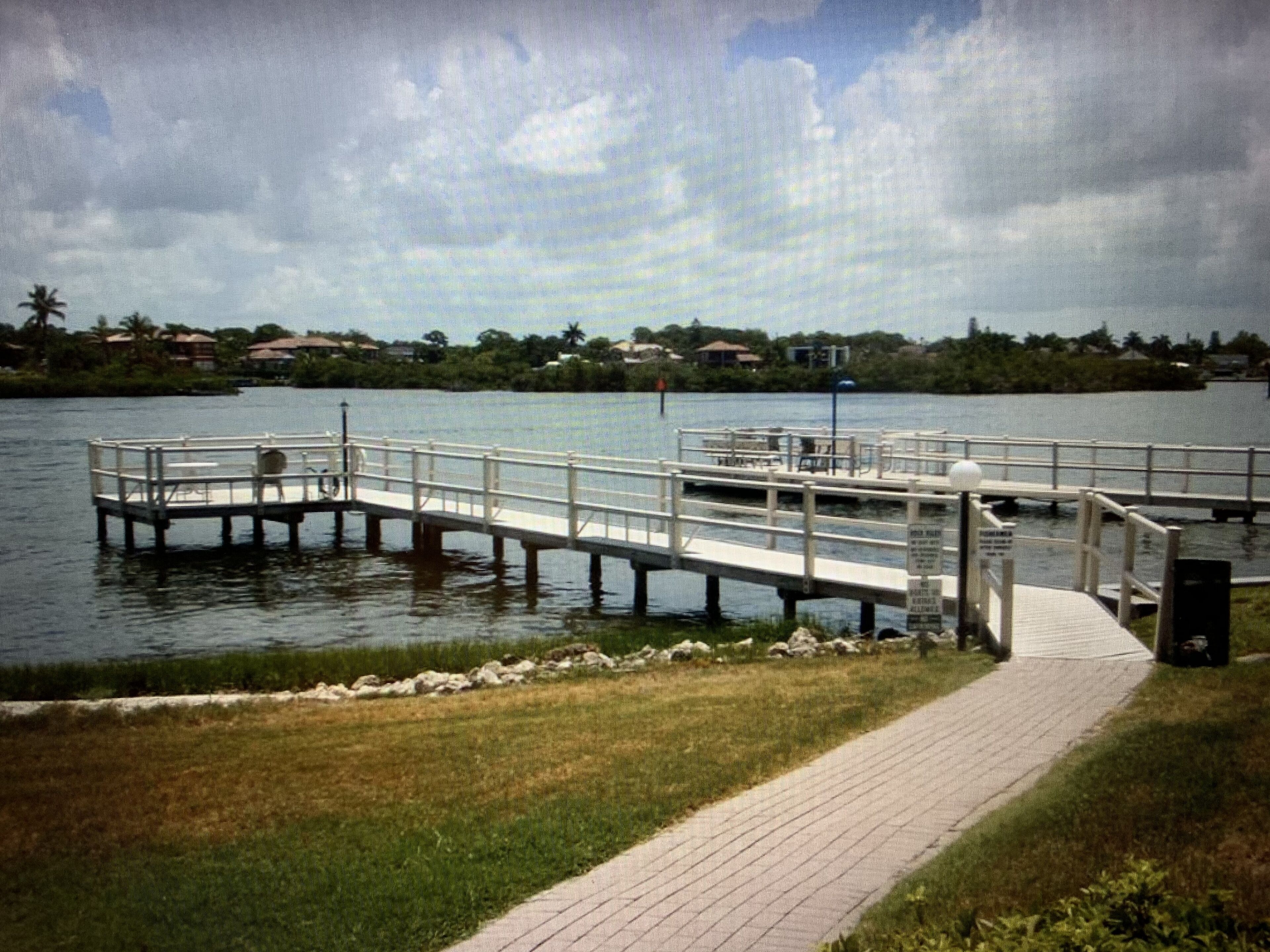 A waterfront dock with a walkway leading to a boat.