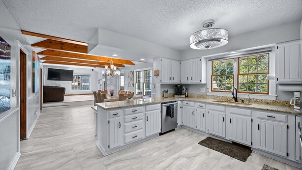 A spacious kitchen with white cabinetry, a granite countertop, and a large island. -  AMAZING & A PARTY BARN… HOT TUB, PL TBl, PNG PNG, & ARCADE!  ACCESS TO POOLS! (West Des Moines)