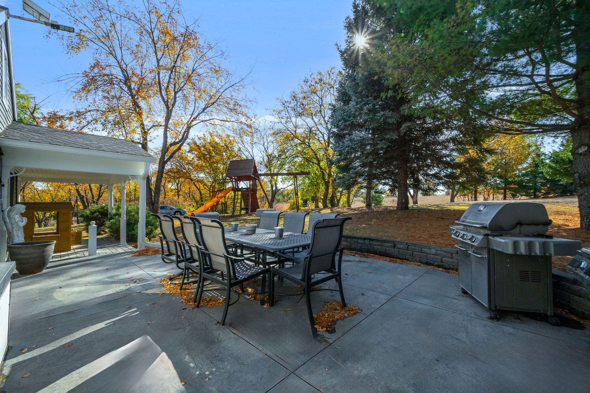 Une terrasse extérieure équipée d’un barbecue, d’une table à manger et de chaises.