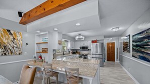 A modern kitchen with granite countertops, stainless steel appliances, and a central island with bar stools. -  AMAZING & A PARTY BARN… HOT TUB, PL TBl, PNG PNG, & ARCADE!  ACCESS TO POOLS! (West Des Moines)