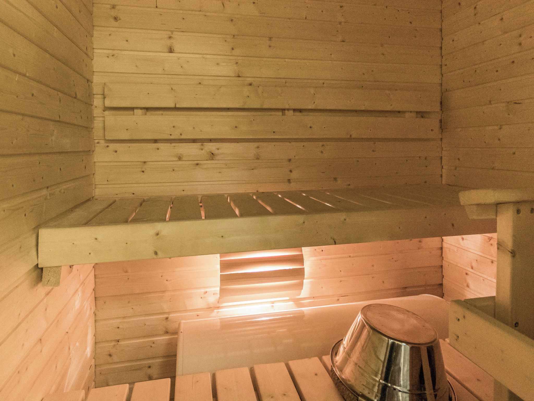 A sauna room with wooden walls and a bench.