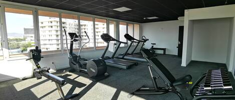 A gym with treadmills, elliptical machines, and weight benches.