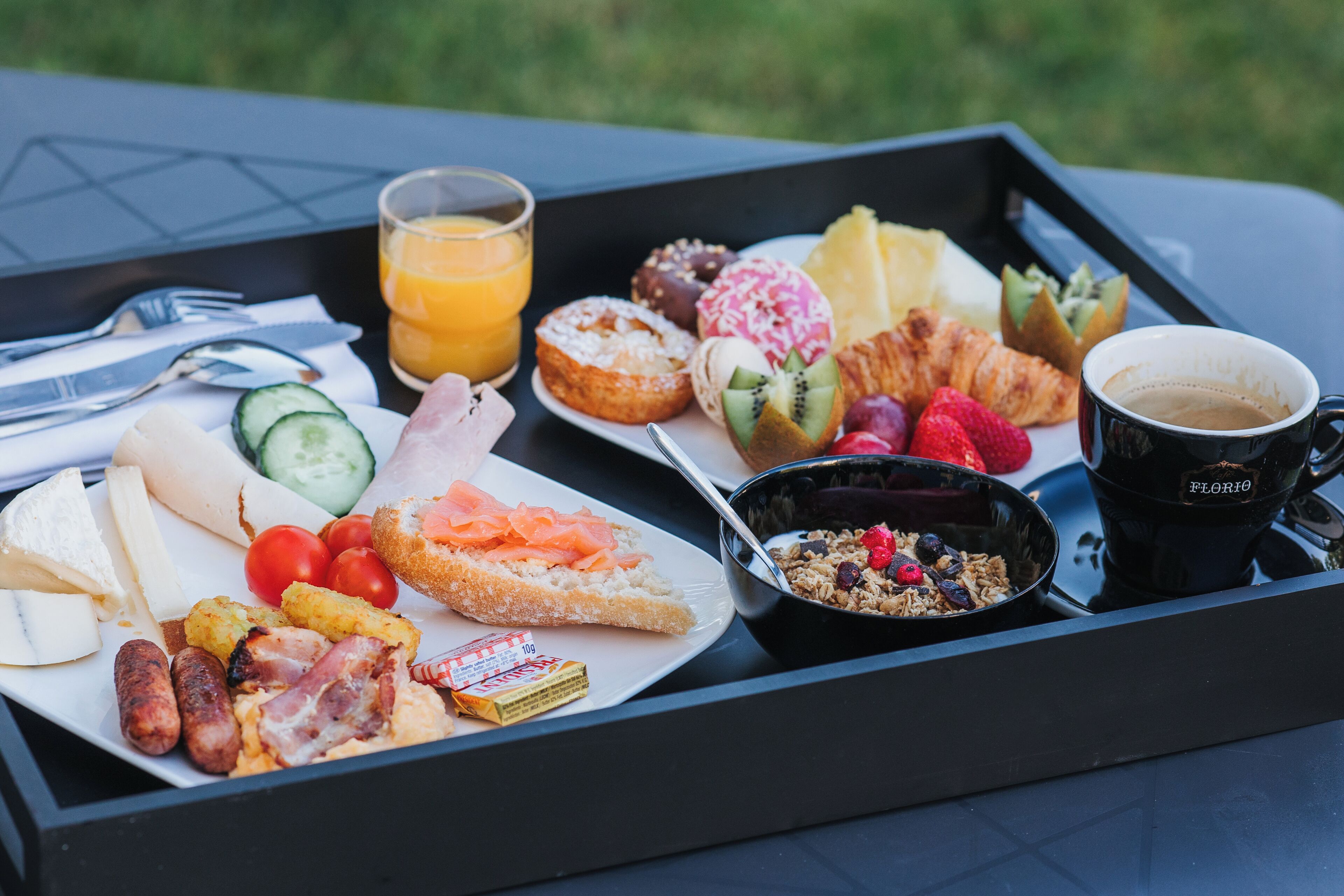 Ein Frühstückswagen mit verschiedenen Speisen, darunter Croissants, Würstchen und eine Tasse Kaffee.