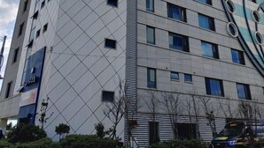 A modern hotel building with a unique angular design, multiple floors, and a prominent sign indicating it is a hotel.