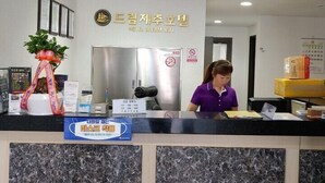 A hotel reception desk with a sign reading "HOTEL DREAM JEJU".
