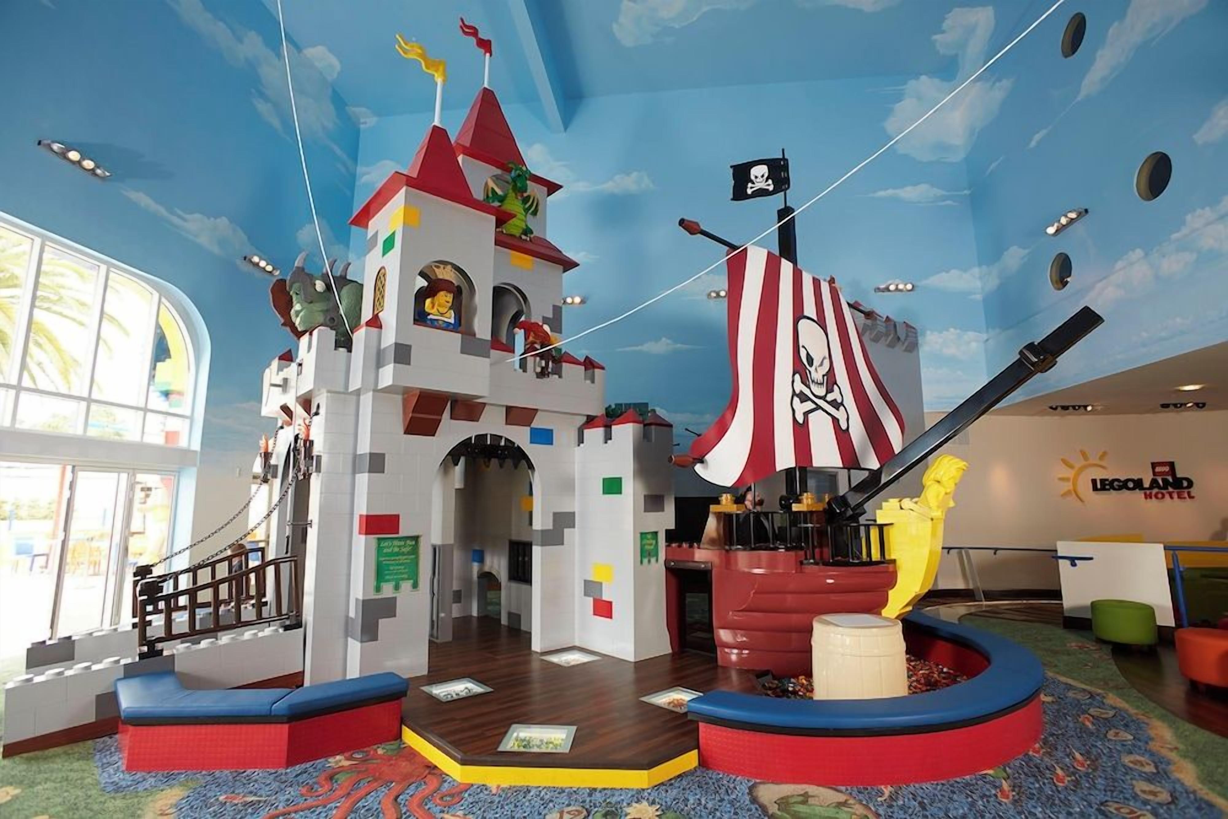 A LEGO-themed play area with a pirate ship, a castle, and a flag.