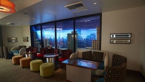 Un moderno vestíbulo de hotel con vista a la ciudad, asientos cómodos y una recepción.