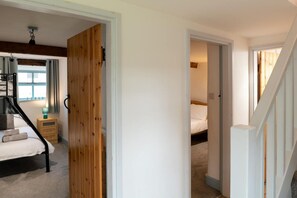 A bedroom with a bed, bedside table, and a wooden wardrobe.