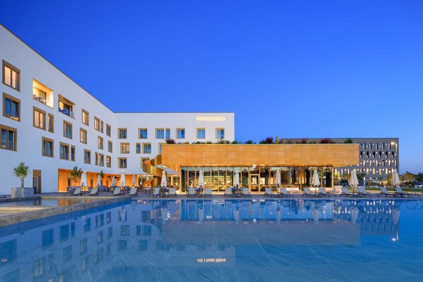 A hotel with a swimming pool, outdoor seating, and a modern building facade. - mk | hotel tirana (Preze)