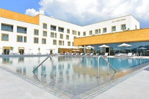 A hotel with a swimming pool, sun loungers, and umbrellas. - mk | hotel tirana (Preze)