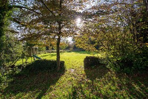 A park with a playground, a grassy area, and a tree-lined path. - Ty Fferam Bailey: A beautiful 7 bed holiday home in Anglesey (Bodorgan)
