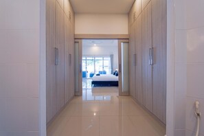 Un pasillo que conduce a un dormitorio con cama, ventana y puerta.