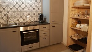 Una cucina con schienale piastrellato, moka, lavello e mobili in legno.