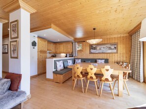 A wooden interior with a dining area, a bench, and a kitchen.
