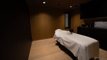 Relax in this serene space with a single bed, TV, and table.