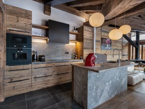 Eine moderne Küche mit Holzschränken, einer Marmorinsel und integrierten Geräten.