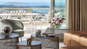 Ein stilvoller Lounge-Bereich mit Meerblick, ausgestattet mit einer Couch, runden Tischen und Dekoration.