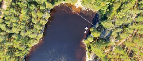 An aerial view of a lake surrounded by dense forest.