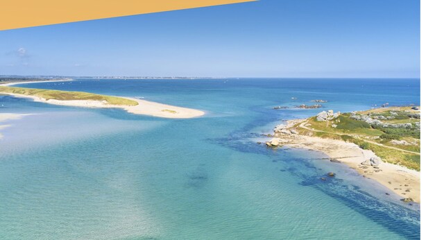Un paysage côtier avec une eau d’un bleu limpide et des plages de sable.