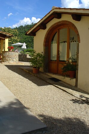 A building with a stone facade, a wooden door, and potted plants.