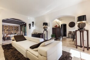 Ein modernes Wohnzimmer mit Sofa, Essbereich und Blick ins Freie.