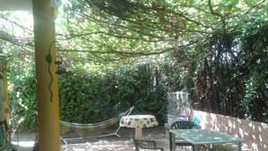 An outdoor patio area with a table and chairs, surrounded by greenery and a hammock. - The River Lee Hotel in Cork (Espartinas)