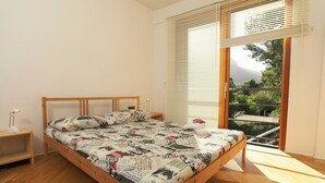 Un dormitorio con una cama de madera, una mesita de noche y una ventana con persianas.
