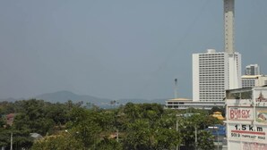 Panoramica di una città con una torre imponente e un edificio con un cartello che indica 'BUNGY JUMP'.