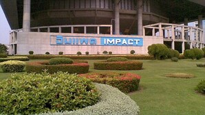 A modern building with a large sign reading 'Suwon Impact.'