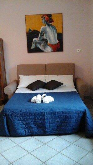 Ein Schlafzimmer mit einem Bett, Kissen und einem Bild an der Wand.