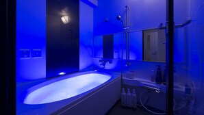 A modern bathroom with a large bathtub, a glass shower enclosure, and a mirror. - Jyubankan - Adults Only (Yokohama)