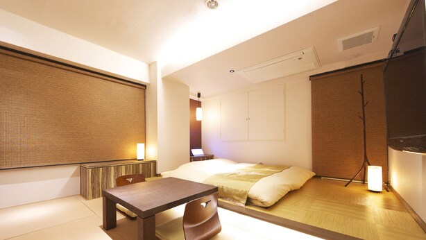 A traditional Japanese-style room with tatami flooring, a low table, a bed with a futon, and a sliding shoji screen. - Jyubankan - Adults Only (Yokohama)