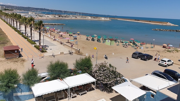 A beach with umbrellas, chairs, and a parking area. - 4 Seater Room for Rent With Private Bathroom and Wifi - Molise (Montenero di Bisaccia)