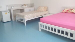 A bedroom with a bed, a small desk, and a nightstand. - Room-impact Don Mueang Bangkok Guest Hou (Pak Kret)