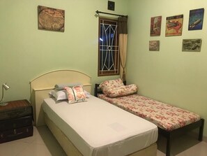 Un dormitorio con dos camas, una ventana con cortinas y varias decoraciones en la pared.