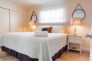 A neatly arranged bedroom with a large bed, two bedside tables, and a wardrobe.