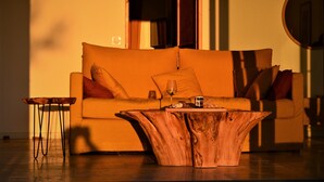 Una sala moderna con un sofá, una mesa de centro de madera y una mesita auxiliar.