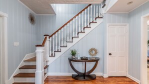 Un escalier avec des balustrades blanches et des marches en bois menant à un palier.