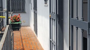 A narrow corridor with a tiled floor, metal railings, and a wheelbarrow with flowers. - Uno sguardo su Porta Palazzo (Turin)