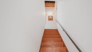 A staircase with wooden steps and a metal handrail, leading to a landing with a framed picture on the wall. - Casa Gallizza by Wonderful Italy (Cefalù)