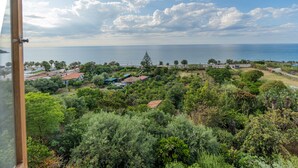 A coastal landscape with a view of the sea, dense greenery, and scattered buildings. - Casa Gallizza by Wonderful Italy (Cefalù)