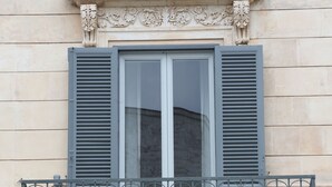 A building facade with a window featuring a balcony with ornate metal railings. - 1940 Luxury Accommodations by Wonderful Italy (Ostuni)