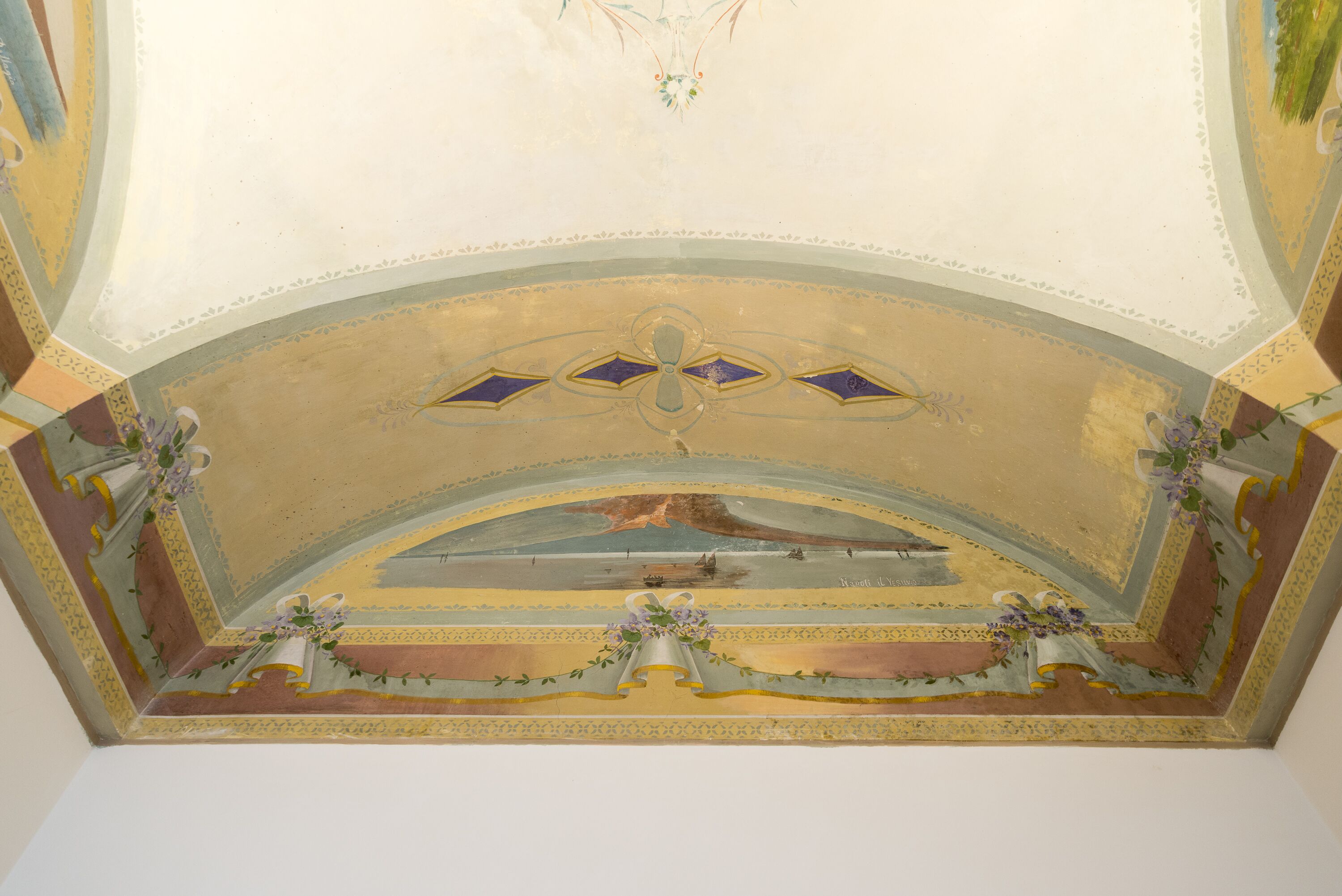 Un plafond orné de motifs décoratifs, comprenant un médaillon central et des motifs floraux.