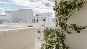 A rooftop terrace with white buildings, a clear sky, and some greenery. - 1940 Luxury Accommodations by Wonderful Italy (Ostuni)