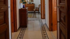 A hallway with wooden doors, a chandelier, a mirror, a dresser, and a chair. - Charme and Comfort near Cinque Terre by Wonderful Italy (La Spezia)
